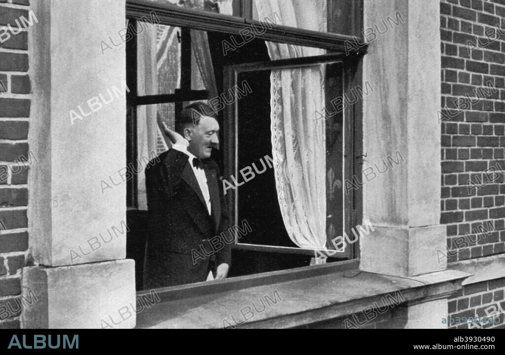 Adolf Hitler in Bayreuth, Germany, 1936. Hitler (1889-1945), attending the annual Bayreuth Festival at which Richard Wagner's operas are performed, acknowledging the acclaim of a crowd beneath his window. A print from Adolf Hitler. Bilder aus dem Leben des Führers, Hamburg: Cigaretten/Bilderdienst Hamburg/Bahrenfeld, 1936.