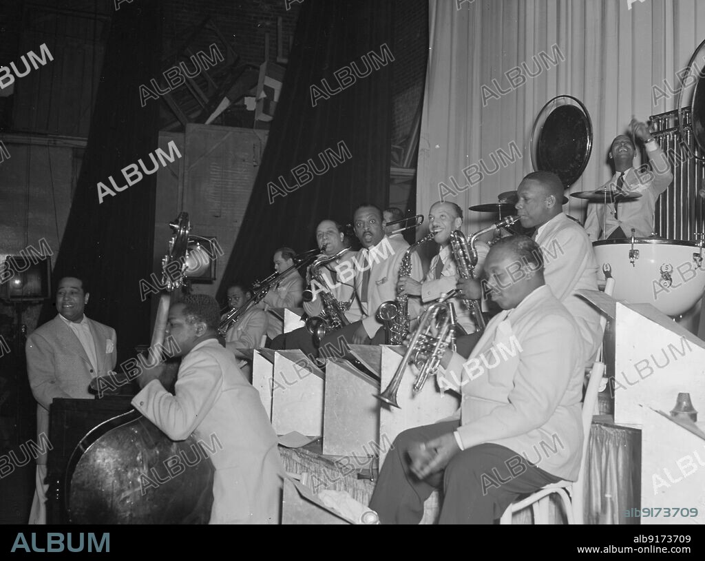 WILLIAM PAUL GOTTLIEB. Portrait of Duke Ellington, Junior Raglin, Tricky Sam Nanton(?), Juan Tizol, Barney Bigard, Ben Webster, Otto Toby Hardwick(e), Harry Carney, Rex William Stewart, and Sonny Greer, Howard Theater(?), Washington, D.C., 1938.