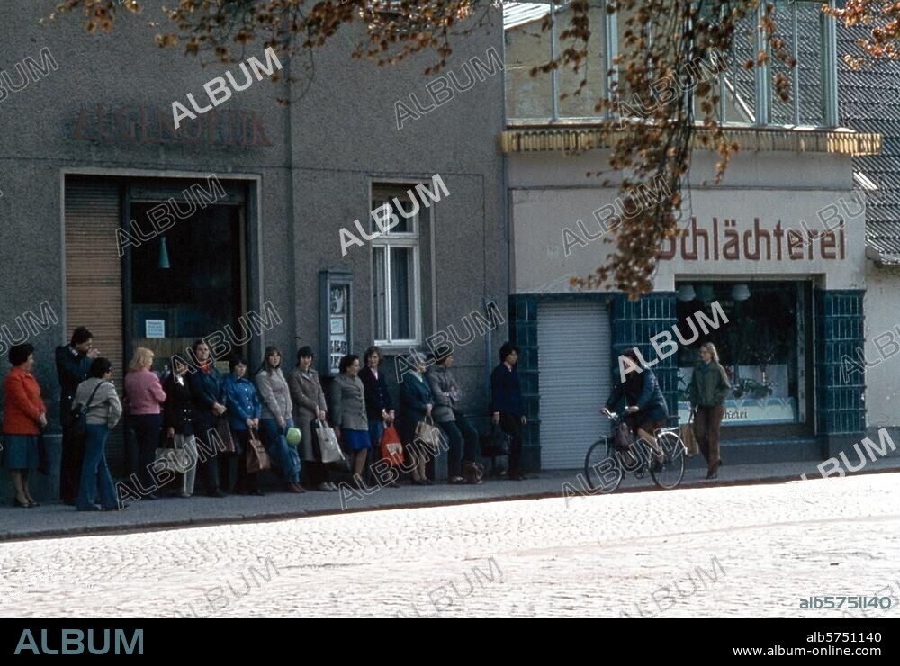 Handel:. Käuferschlange. Schlangestehen vor einer noch geschlossenen Fleischerei in Potsdam (DDR). Foto, undat. (80er Jahre?).