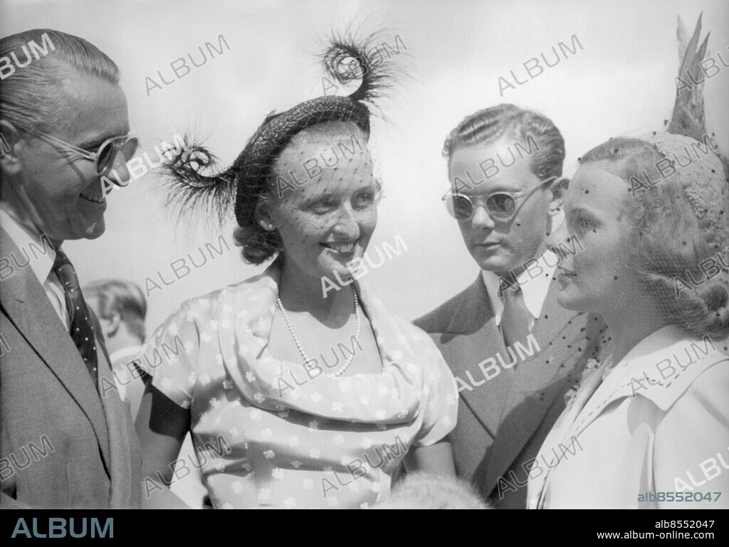 Orig. bildtext... SVENSKT DERBY 1949. Disp. Pelle Söderlund med sin fru stjärnmannekängen Kim sågs tillsammans med dir. Tom Högman och fru Karin Leyon. Anm. Mannekänger Flor Fjädrar Pärlhalsband Prickar Prickigt Solglasögon CD420 persons: KARIN LEYON;TOM HÖGMAN;KIM SÖDERLUND;PELLE SÖDERLUND sites: SVERIGE.