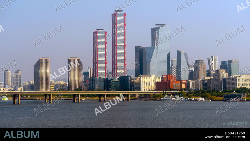 View across the Hangang River. 'The Parc 1 Tower (with red piping), is a supertall skyscraper in Seoul, South Korea. It stands 333 m (1,093 ft) and contain 69 floors. Construction stopped in 2011 but resumed in early 2017. Seoul, South Korea.