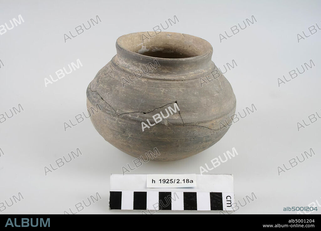 Spherical pot with flat bottom, polished pottery, decorated with ridges. Bonding, small crack in the neck. Contains cremated residues., Pot, earthenware (Frankish, Mayen), h: 11 cm, diam: 14.2 cm, vmeb 600-700, Netherlands, South Holland, Katwijk, Rijnsburg, cemetery.