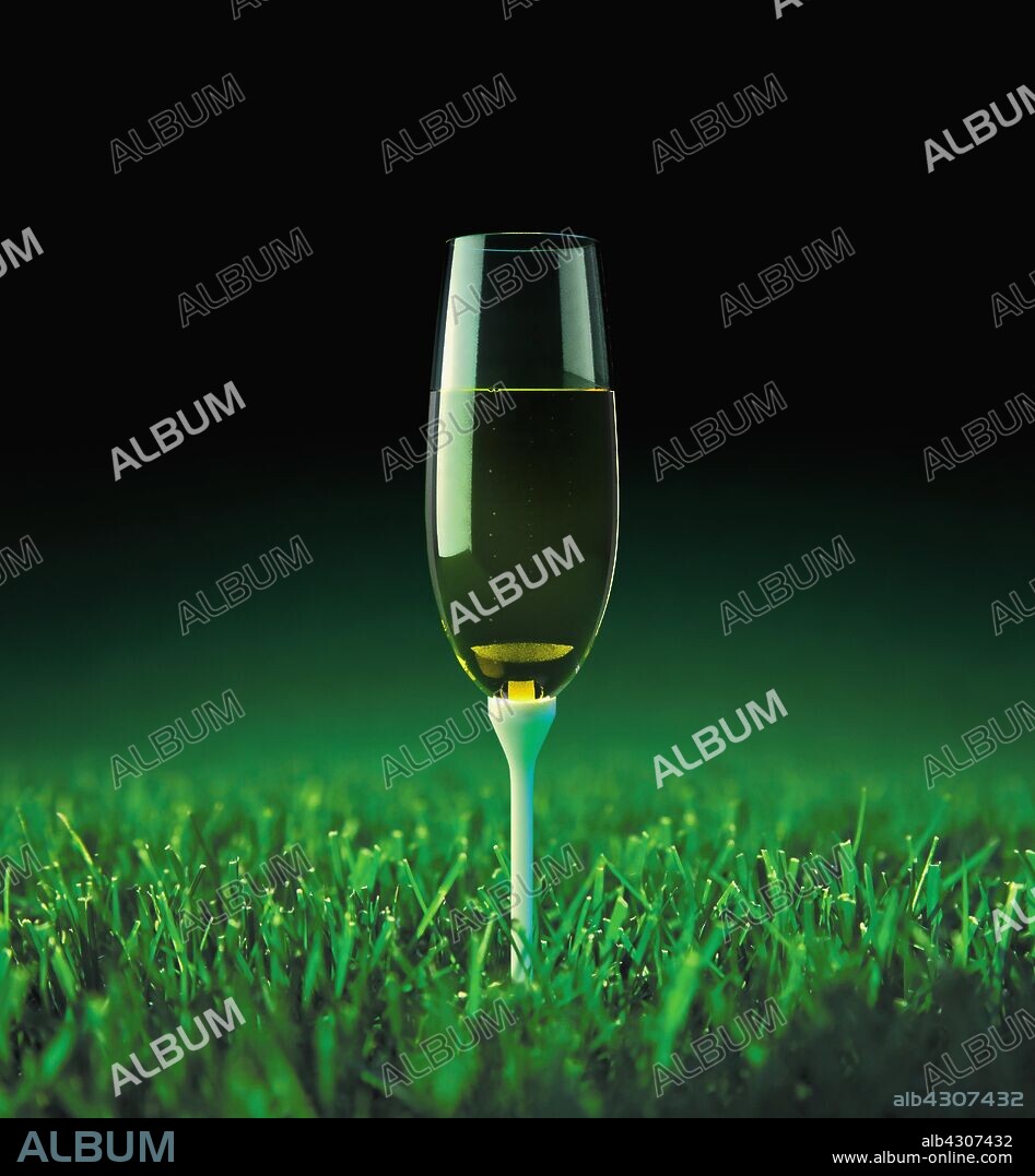 Champagne on golf tee in grass.