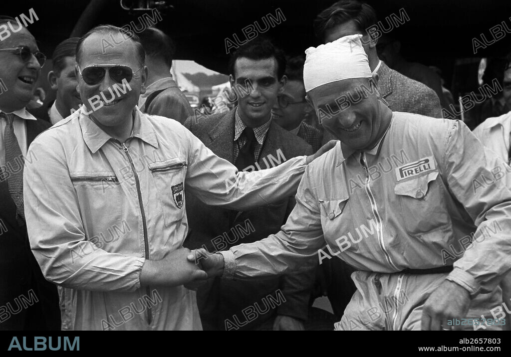 BRM driver Reg Parnell with 1950 Formula 1 World Champion Driver Nino Farina of the Alfa Romeo team in the pits at the British Grand Prix, Silverstone, England, 14th July 1951.
