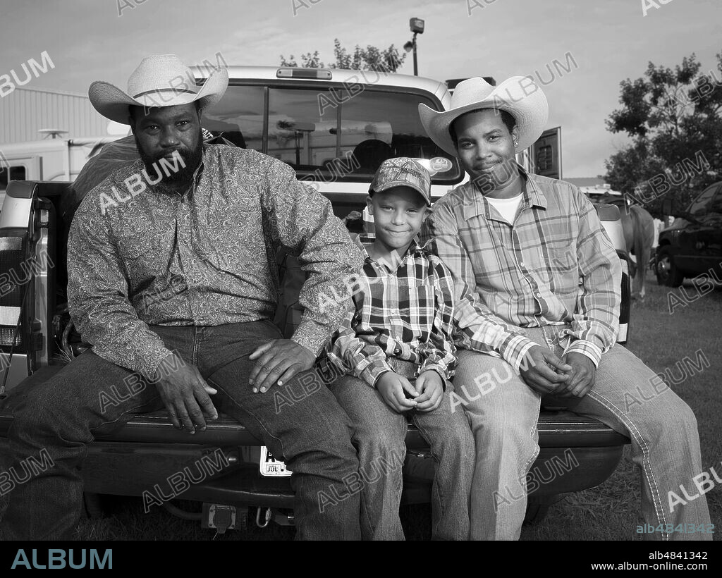 THAD HEARD, THADDEUS HEARD and TYLER HEARD. August 2, 2014, Atlanta, Georgia, USA: THAD HEARD, with sons TYLER, and THADDEUS are three generations of cowboys at the Bill Pickett Rodeo in Atlanta. Thad, a retired fireman, has been riding in the rodeo since 1994 in the steer wrestling competition. Thaddeus is a cook at Waffle House and plans to start competing in the rodeo when Tyler is a little older. (Credit Image: © Forest McMullin/ZUMA Wire).