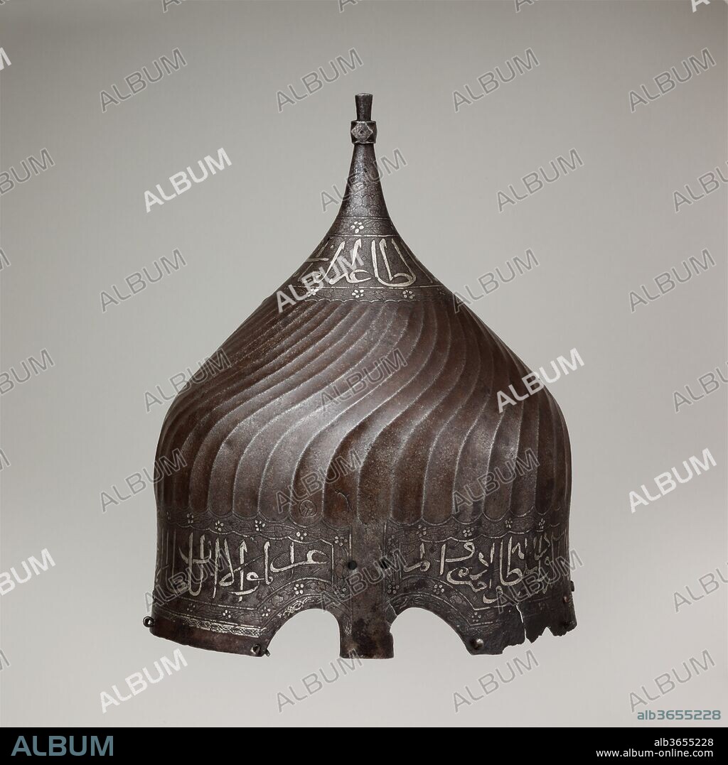Turban Helmet. Culture: Iranian. Dimensions: H. 12 1/4 in. (31.1 cm); Diam. 9 1/2 in. (24.1 cm); Wt. 2 lb. 5.1 oz. (1051.8 g). Date: late 15th century.
Helmets of this type are usually called turban helmets becuase of their large bulbous shape and the flutings that imitate the folds of a turban. Because certain dervish groups wore turbans wound with a prescribed number of folds to represent an important mystical number, it is likely that turban helmets were regarded not merely as armor but also as a kind of religious insignia, their very shape marking the wearer as a fighter in a Holy War.
Turban helmets, together with mail-and-plate armor of matching decoration, were intended for the heavy cavalry and are recorded as early as the fourteenth century. The examples exhibited here appear to have belonged to the dynasty of Ak-Koyunlu (White Sheep Turkoman), which ruled northwestern Iran and Anatolia in the fifteenth century. The inscriptions, damascened with gold and silver, glorify temporal rulers, wish the owner well, or give advice on how to attain virtue.