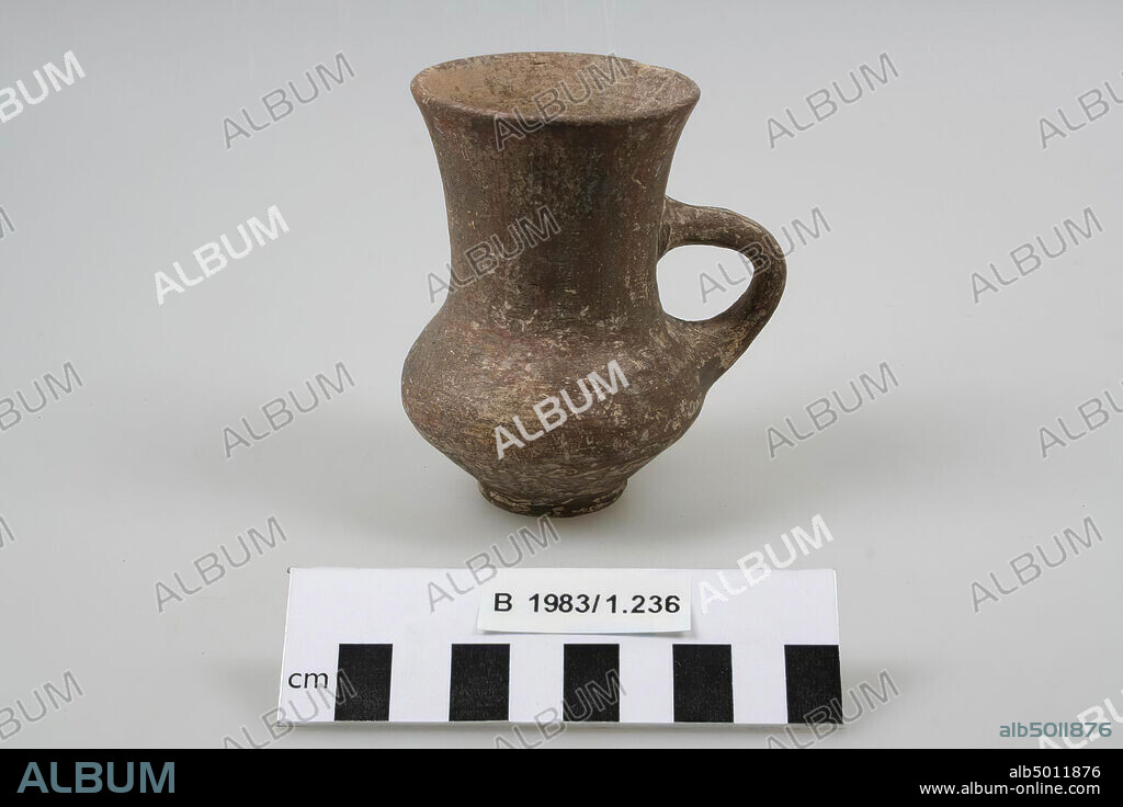 An earthenware cup with a sagged ball body and a high funnel-shaped neck and rim. A vertical handle connects the neck with the shoulder., Crockery, pottery, H 9.3 cm, D 6.5 cm, B incl. Ear 8.1 cm, Iron Age III 700-600 BC, Iran.
