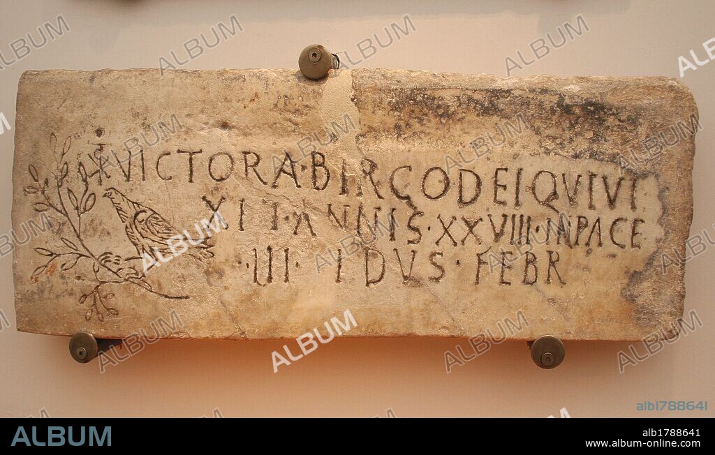 Early Christian Art. Italy. Early Christians. Roman tombstone with Christian iconography. Inscription: Victoria, consecrated virgin, who lived 28 years. Christian phrase appears "in pace". The symbol of the dove and the olive branch and the monogram of Constantine T. 4th century AD. Baths of Diocletian, part of the National Roman Museum Rome. Italy.