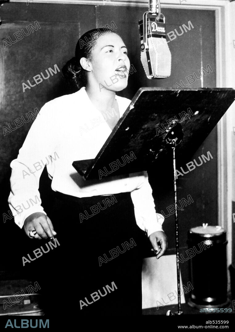 American jazz singer Billie Holiday singing into a microphone at a Decca recording session, 1946.