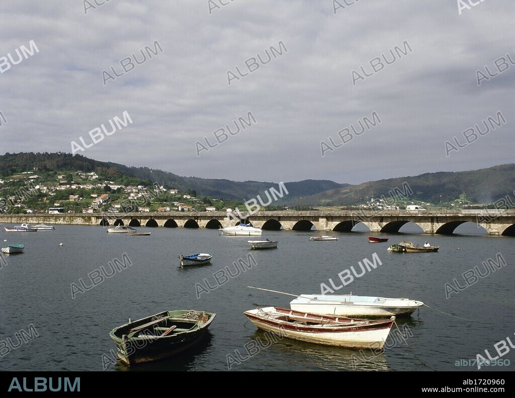 GALICIA. PONTEDEUME. Vista del PUENTE sobre el RIO EUME, construido por Fernán Pérez de Andrade entre los años 1380 y 1386. Reformado en el siglo XIX, conserva 15 de los 79 arcos originales. En primer término, BARCAS DE PESCA. Provincia de A Coruña. España.