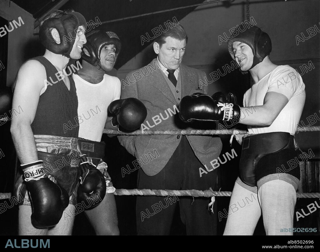 Orig. bildtext... GET-TOGETHER AT BRIGHTON. (L. TO R.) TEDDY PECKHAM, sparring partner to McCarthy, YOLANDE POMPEY of Trinidad, TOMMY FARR, the former British heavy-wt. champion, and SAMMY McCARTHY, seen during a break in training at Brighton. Pompey fights a return with Bobby Dawson of USA, at Nottingham on the 31st., and McCarthy puts up his British and Empire feather-wt. title against Billy Kelly in Belfast on the 22nd. Anm. Sparringpartner Boxhandskar Huvudskydd Blicken Jämförelser Kontraster Kvartett Leenden Rast Paus Kavajer Träningsdräkter Träning Kampsporter Samförstånd CD394 persons: SAMMY MCCARTHY;TOMMY FARR;YOLANDE POMPEY;TEDDY PECKHAM sites: TRINIDAD OCH TOBAGO*;STORBRITANNIEN;BRIGHTON.