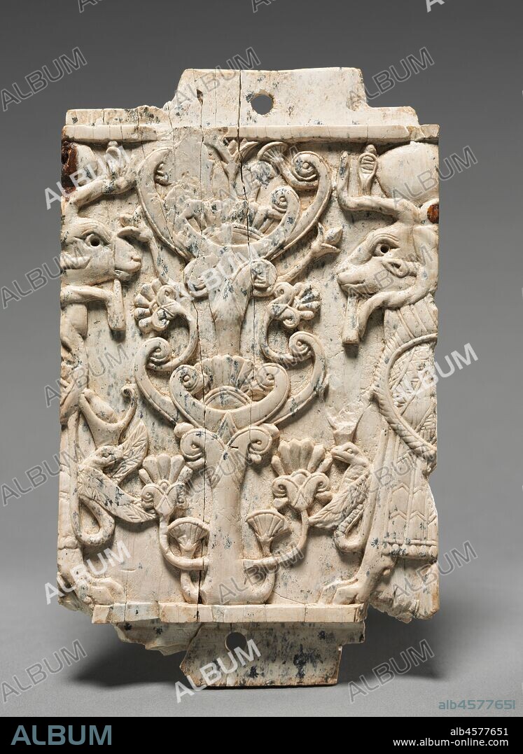 Decorative Plaque: Ram-Headed Sphinxes Flanking a Sacred Tree, 900-800 BC. This small plaque was executed in the Phoenician style with symmetrical compositions, elongated figural proportions, and Egyptian subjects and motifs. Examples have been found throughout the Middle East, but thousands come from Nimrud where most were excavated in the storerooms of a military arsenal built by King Shalmaneser II (858-824 bc). When the Nimrud palace was sacked in the 7th century bc, these ivories were thrown into a well, where Sir Max Mallowan (the husband of Agatha Christie) discovered them in 1951. The monumental wall relief (1943.246) was found at the same Assyrian palace at Nimrud.