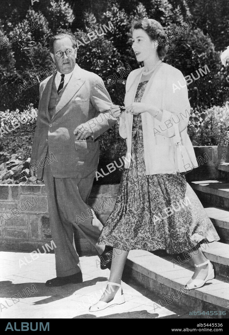 The New Queen In Africa - Before Tragic News Of Father's Death -- Princess Elizabeth, now Queen following the sudden, tragic death of her father, King George VI, walks through the Kenya sunshine with Sir Philip Mitchell, Governor of Kenya, at Sagana lodge, Nyeri, the Colony's wedding present to the Princess and her husband, the Duke of Edinburgh. (This picture of the Royal tour was received in London just a few hours after the announcement of the King's death). February 02, 1952.