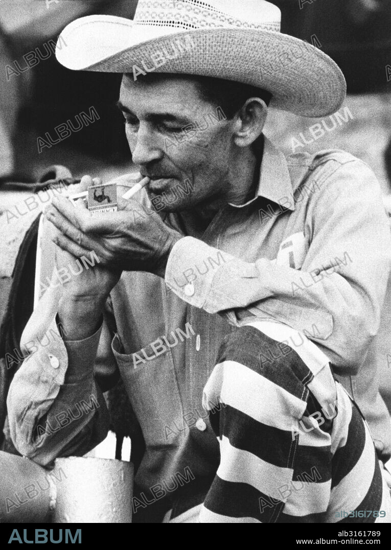 McAlester, Oklahoma: September. 1971. A cowboy prisoner participant in the prison rodeo lights up a Camel cigarette. He says he's been in prison nine times, and has been accused of coming back just for the rodeo.