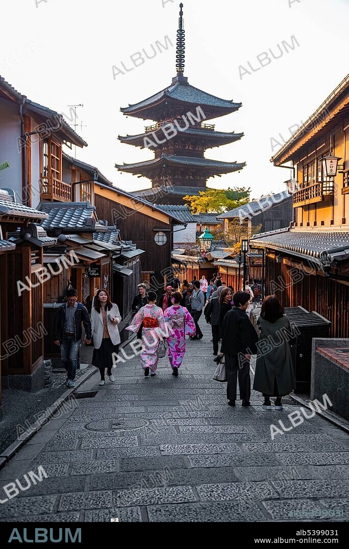 Pedestrian with kimono, Yasaka dori historical street in the Old Town with traditional Japanese houses, behind five-storey Yasaka pagoda of the Buddhist Hōkanji Temple, Kyoto, Japan