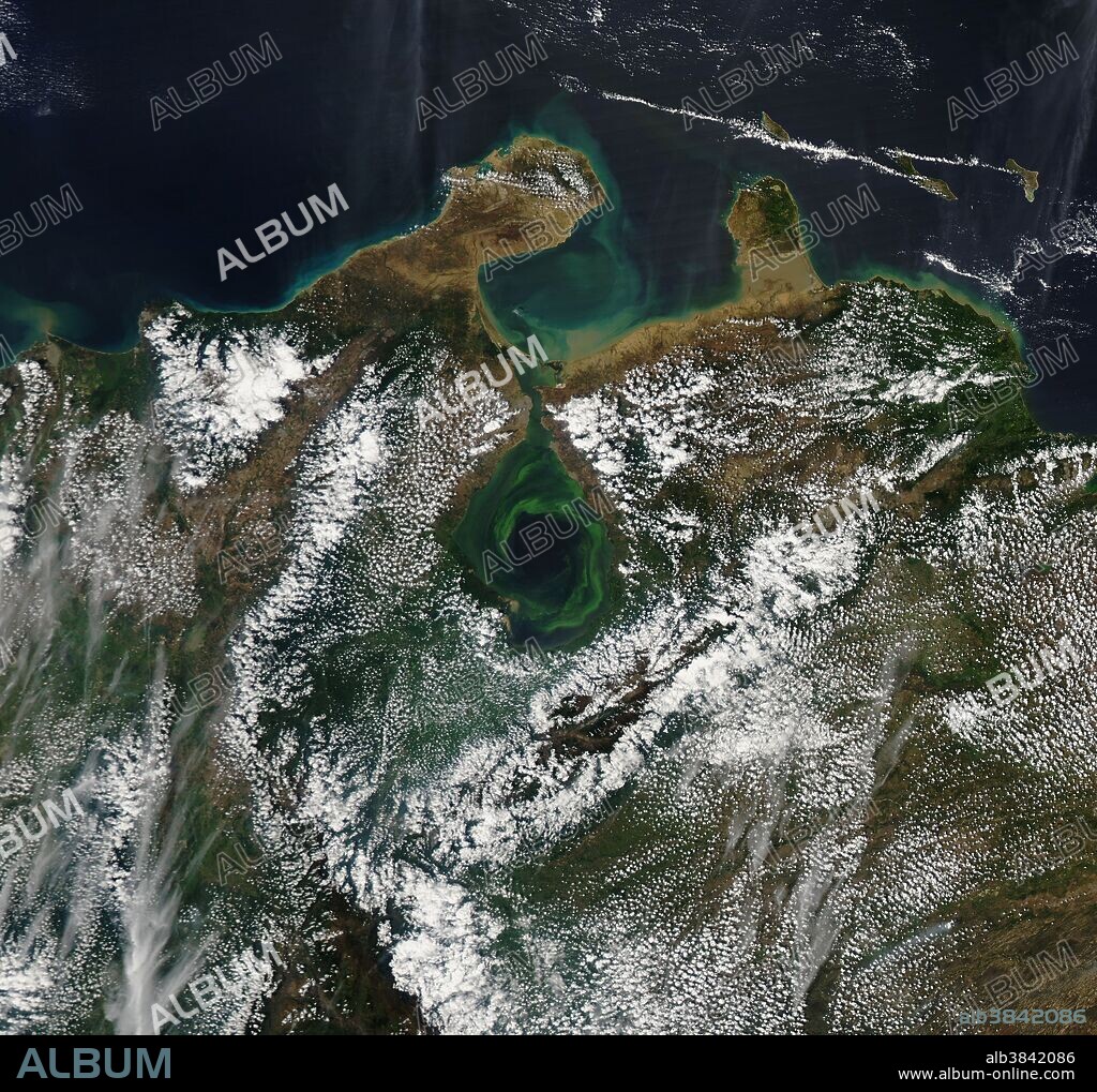 Lake Maracaibo, Venezuela, with swirls of green plant life, captured by the Moderate Resolution Imaging Spectroradiometer (MODIS) on NASA's Aqua satellite in February 2017. Heavy rain mixes the water layers in the lake, freeing up nutrients for plants to grow. The swirling currents form as water comes in from the Caribbean through the narrow strait.