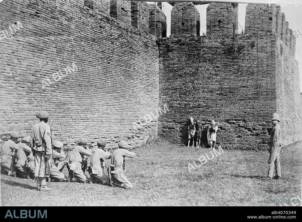 WILLOUGHBY WALLACE HOOPER. Execution of Burmese dacoits at Mandalay. A glass copy negative of a print showing three Burmese dacoits about to be executed by a British firing squad in front of the walls of Mandalay. Hooper Collection: Execution of dacoits at Mandalay. 15 Jan. 1886. Photograph. Source: Photo 447/8(1).