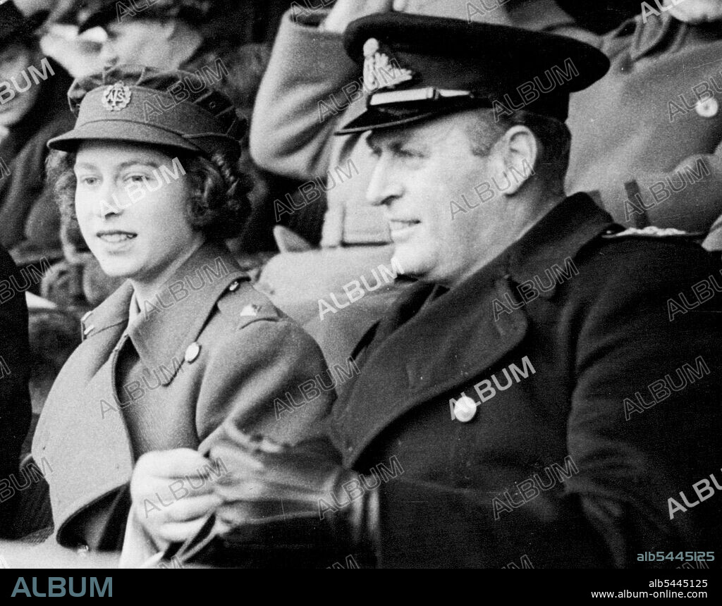 The King and Queen And Second Subaltern Elizabeth Windsor of The Watch Cup Final. Second Subaltern Elizabeth Windsor of the A.T.S. (H.R.H. Princess Elizabeth) and Prince Olaf of Norway watching the match. Princess Elizabeth looks like setting a new hair style for the women's forces - her hair was arranged in a couple role of curls - the back. Several ATS officers in the crowd remarked on the attractiveness of the Princess's hair-do. April 8, 1945.