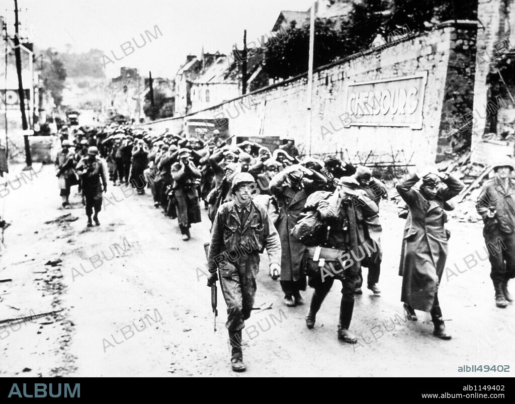 US GI's march German prisoners out of Cherbourg after the Battle of Cherbourg, June 1944.