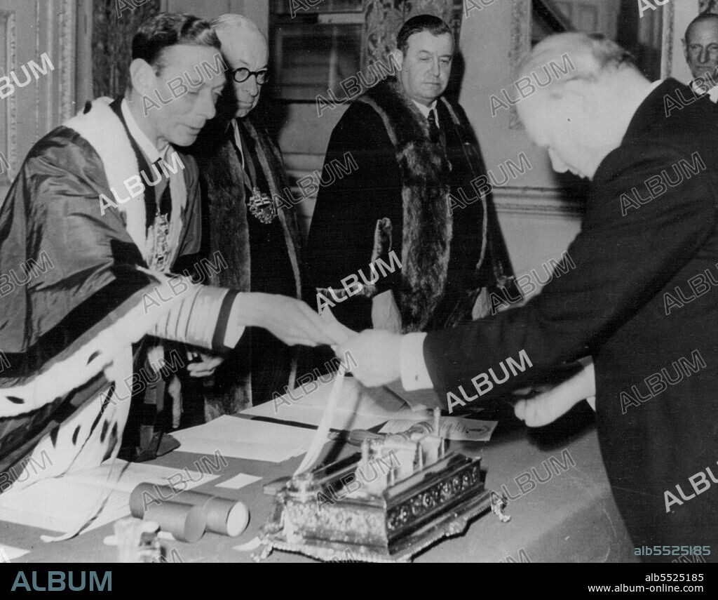 King Presents Award To Churchill -- King George VI (left) presents former Prime Minister Winston Churchill with the "Freedom of the Worshipful Company of Ship-Wrights" at a meeting of the court of the company at the Mansion house, London, Oct. 24. Others in photo are unidentified. October 31, 1945. (Photo by Associated Press Photo).