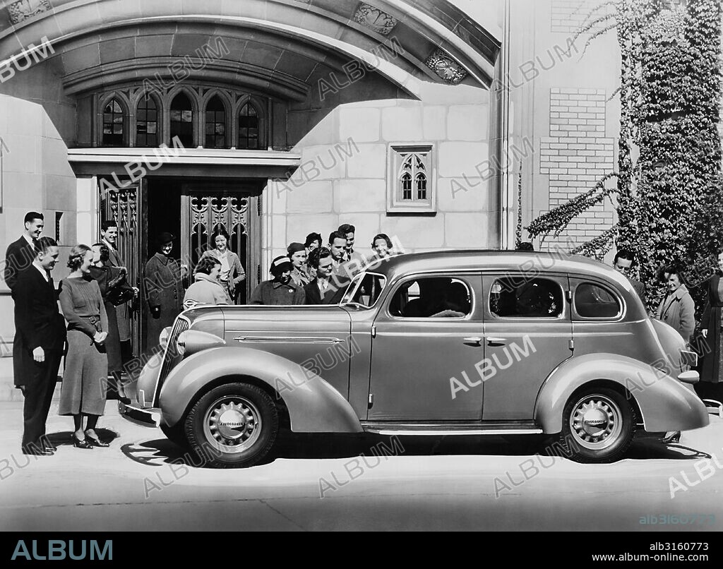 United States: 1936 A crowd of people admiring a new 1936 Studebaker Dictator.