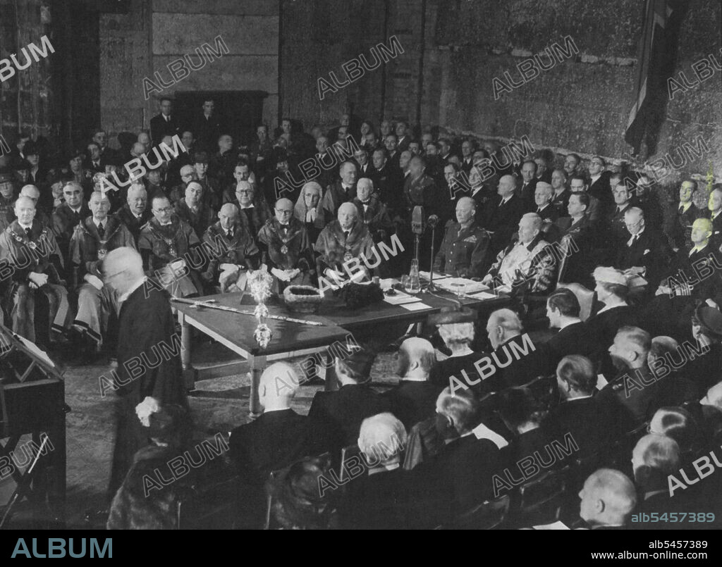 General Eisenhower Receives Freedom Of The City Of London -- General Eisenhower seated with the Lord Mayor, Sir Frank Alexander, at the Civic Table, on which lies the City Sword, as the acting City Chamberlain makes his address, asking the Supreme Allied Commander to accept a Sword of Honour of the hands of the Lord Mayor.General of the Army Dwight D. Eisenhower drove through cheering crowds to the Guildhall, where he received the Freedom of the City of London. The Supreme Allied Commander was afterwards guest of honour at a luncheon in the Mansion House, which was attended by the Prime Minister, the City Corporation, members of the War Cabinet, and many other distinguished persons. June 12, 1945. (Photo by Plant News Ltd.).