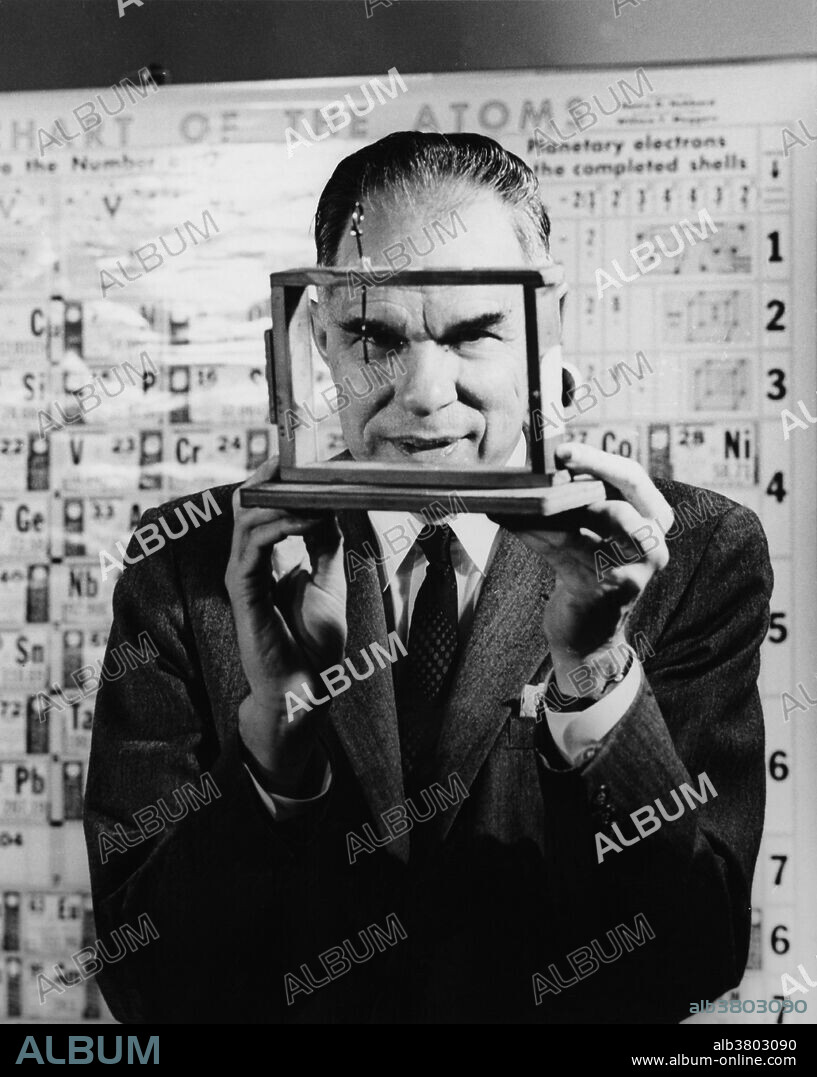 One of the co-discoverers of plutonium, Dr. Glenn T. Seaborg, holds a historic device: a balance which was used in research during World War II for the first weighing of the new man-made element. The amount weighed was tiny, only about on-millionth of the weight of a dime. Suspended from the upright bar of the balance is a hairlike quartz fiber, too fine to show up in the picture. The Nobel laureate Dr. Seaborg, who acted as the Chairman of the U.S. Atomic Energy Commission, worked with colleagues in an experiement that positively identified the trans-uranium element which, like uranium, is fissionable and thus of tremendous present and potential benefit to mankind.