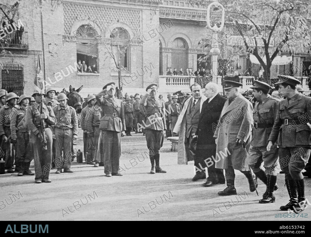 Azaña  pasa revista a la 46ª división del Ejército Popular en la localidad de Alcalá de Henares, ciudad natal de Azaña. Lo acompaña el presidente del Consejo de ministros, Dr. Negín, a su derecha. A su izquierda está el general Miaja, el jefe del Ejército en el centro y más a la izquierda, con perilla, el comandante de la 46 división, mayor de milicias, Valentín González, conocido como "El Campesino". La visita se enmarca en la campaña de visitas al frente y unidades del Ejército Popular del presidente de la República, 1937.
