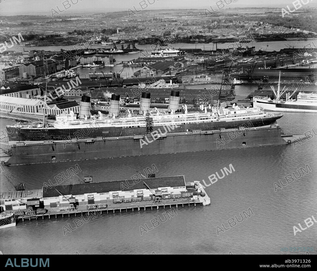 The original RMS 'Mauretania' in the floating dry dock, Southampton, Hampshire, 1933. Designed by Leonard Peskett and built by Swan, Hunter & Wigham Richardson for the Cunard Line, 'Mauretania' was launched in September 1907. Her final Atlantic crossing from New York to Southampton was in 1934 and she departed for the shipbreakers in 1935.