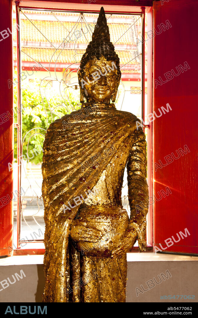The Buddhist temple of Wat Phra Thong, the Temple of the Golden Buddha can be found in the Thalang District of Phuket Island. This unusual temple is named for the golden (or gilded) Buddha image that is buried within the temple precincts so that only the head and shoulders are visible above ground. According to legend, a local buffalo boy attempted to tether one of his charges to an outcrop he thought was a tree stump, but which proved to be the ushnisha or top-knot of a buried Buddha image. For this albeit unintentional heresy, both the boy and the buffalo died. It was later revealed to the boys father in a dream that his son had in fact been transported to nirvana rather than being punished, and when the local lord heard this story he ordered the image dug up and suitably installed in a temple. However, despite the Thalang villagers best efforts, the image could not be fully excavated, and remained buried from the shoulders down. Consequently a roof was erected to shelter the exposed head and shoulders, making the image and surrounding temple a place of great veneration for both local Thais and Chinese migrants. Today the temple is among the most venerated of Buddhist sites not just in Phuket, but in all southern Thailand.