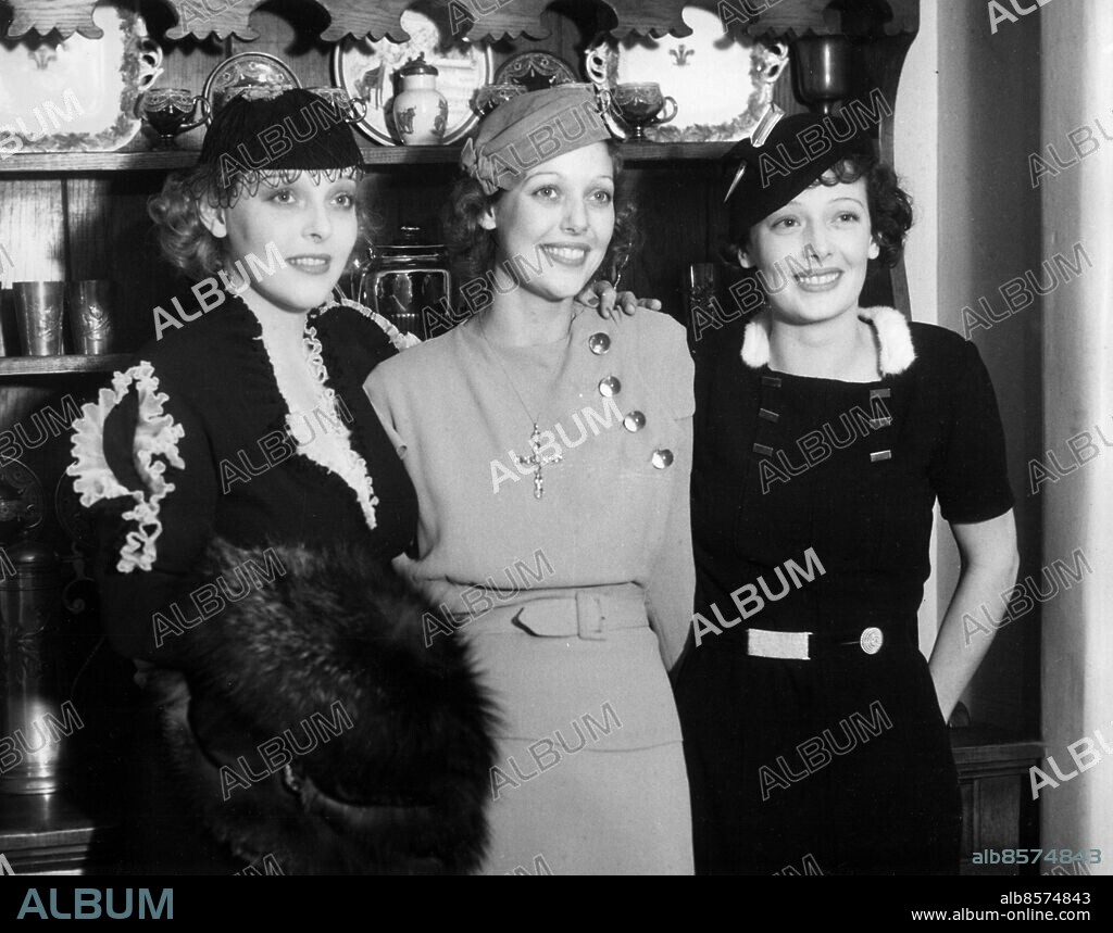 Orig. bildtext... SCREEN FOLK AT CHRISTMAS PARTY. Sally Blane, Loretta Young and Polly Ann Young, a trio of beautiful sisters, shown, left to right, as they attended the Christmas Day party given by Colleen Moore at her Bel Air, Calif., estate. 12/28/33 Anm. L Young, 1913-2000, amerikansk skådespelerska. P A Young, 1908-1997, amerikansk skådespelerska. S Blane, 1910-1997, amerikansk skådespelerska. Filmstjärnor På rad Syskon Systrar Trio CD631 persons: SALLY BLANE;LORETTA YOUNG;POLLY ANN YOUNG sites: USA;BEL AIR.
