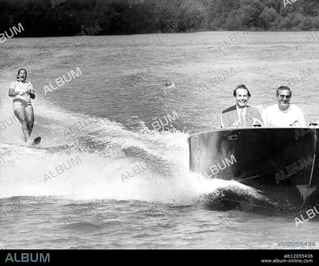 Dr. Christian Barnard takes the wheel of a speedboat accompanied by British coach, David Nations as Dr. Barnard's daughter, Deidre skims over the surface of Ruislip Lido in Middlesex as she prepares for the Wills Water Ski International. Deidre is the South African Water Ski Champion at age 18. 11th June 1968.