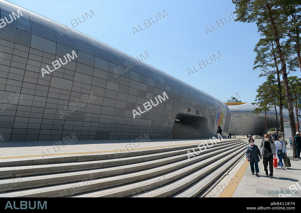 The Dongdaemun Design Plaza, abbreviated as DDP, is a major urban development landmark in Seoul, South Korea designed by Zaha Hadid and Samoo, with a distinctively neo futuristic design characterized by the powerful, curving forms of elongated structures. The landmark is the centrepiece of South Korea's fashion hub and popular tourist destination, Dongdaemun, featuring a walkable park on its roofs, large global exhibition spaces, futuristic retail stores and restored parts of the Seoul fortress. The DDP has been one of the main reasons for Seoul's designation as World Design Capital in 2010. it was officially inaugurated on March 21, 2014.