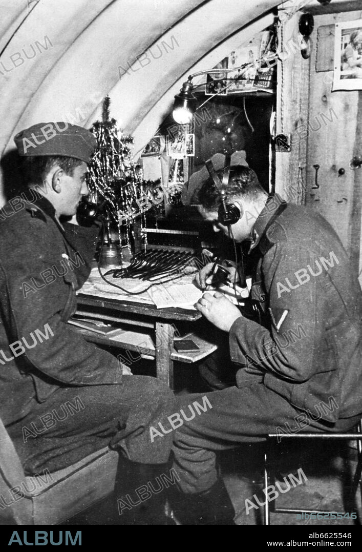 Soldiers of the German Wehrmacht are pictured at work at the radio on Christmas 1940. The Nazi Propaganda! on the back of the image is dated 21 November 1940: "Soldiers' Christmas 1940. Even at Christmasl, the duty has to be fulfilled. Cozily, the candles burn on the Christmas tree, but the war does not know self-assured calmness. The enemy is England - and this means, anything is possible." Photo: Fotoarchiv für Zeitgeschichte/Archiv. 21/11/1940