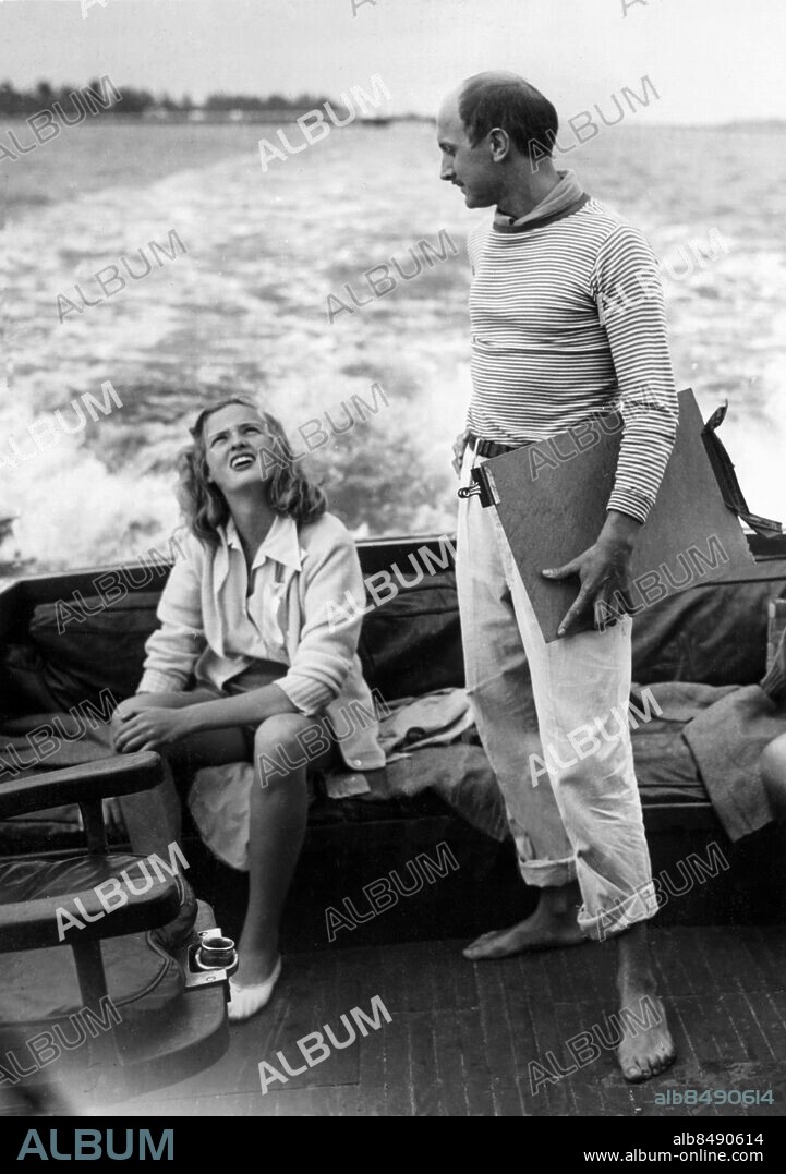 Orig. bildtext... TAKING LIFE EASY AT FAMED RESORT Palm Beach, Fla.- Franz Bueb, famous German artist, is shown chatting with miss Sadja Stokowski, daughter of the noted conductor Leopold Stokowski and the princess Zalstem Zalessky, as they enjoyed a cocktail party cruise on the yacht Geni, owned by Norman Butler of Chicago. Miss Stokowski, whose beauty rivals that of her famous step-mother, Gloria Vanderbilt Stokowski, and artist Bueb are members of the smart set sojourning at this famed society resort. 1-9-46 Anm. F Bueb, 1919-1982, tysk arkitekt, målare och grafiker. Barfota Kölvatten Randigt Profiler Båtar Yachter Samtal Badorter Kryssningar CD532 persons: SADJA STOKOWSKI;FRANZ BUEB sites: TYSKLAND*;PALM BEACH;USA.