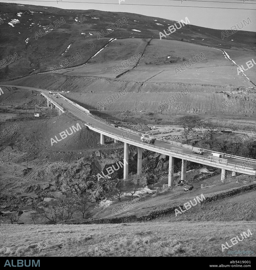 JOHN LAING PLC. A view of the construction of the M6 Motorway through the Lune Gorge, showing the Roger Howe bridge in the foreground, carrying the A685 over the River Lune, and the Lawtland House viaduct in the background, carrying the A685 over the motorway. The work on the Lune Gorge section of the M6 Motorway between Killington and Tebay (Junction 37 - Junction 38) was carried out by John Laing Construction Ltd. Work started in October 1967 and the motorway was opened to traffic in October 1970. The structures in this photograph are located at grid references NY6129602758 and NY6116502666 to the south-east of Roundthwaite.