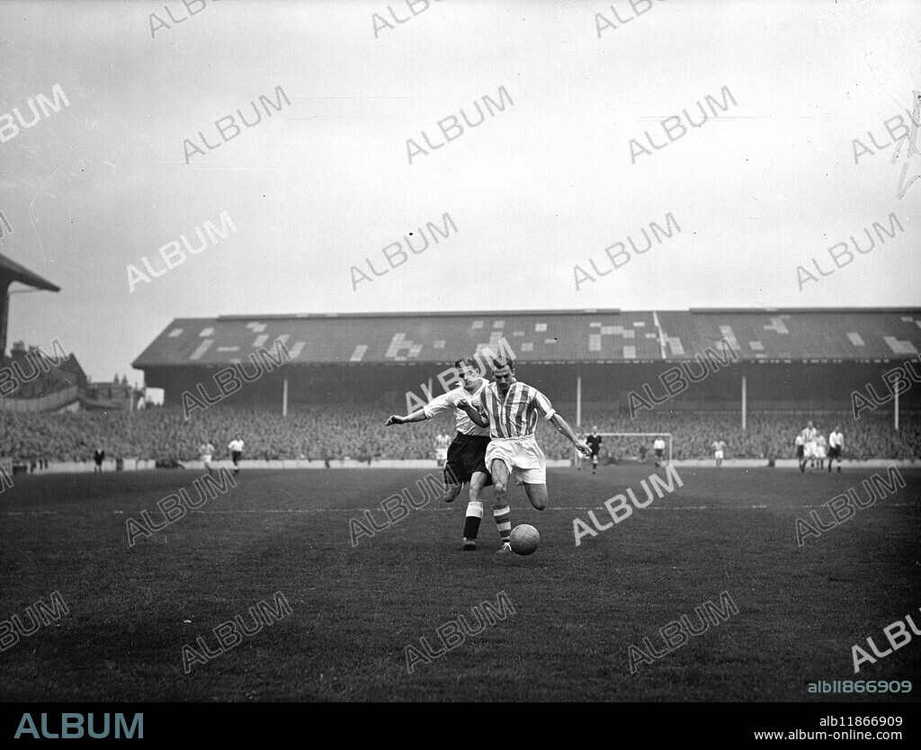 HIGH-SPEED TUSSLE AT WHITE HART LANE. In the high-speed race for the ball at White Hart Lane , London , Stoke City left back John McCUE ( striped shirt ) edges out Tottenham Hotspurs outside right Sonny Walters , during the First Divison football match . ' Spurs ran up a long 6-1 score over Stoke City . 21 October 1950.
