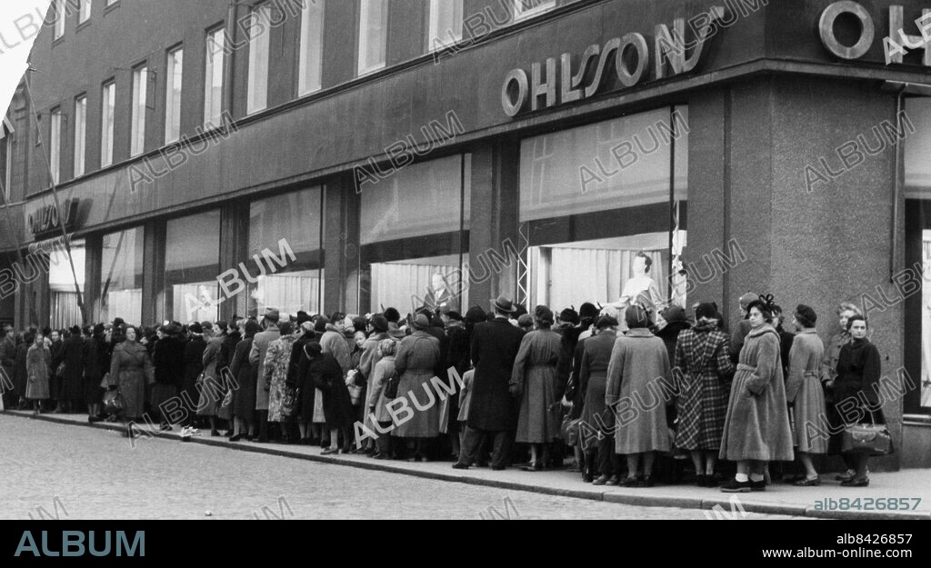 Rea realisation mode dammode damkläder herrmode herrkläder Ohlssons butik på Kärleksgatan i Malmö, 1953. Lång kö ut på Davidshallsgatan.. Foto: Jan Dahlander / Sydsvenskan / IBL Bildbyrå.