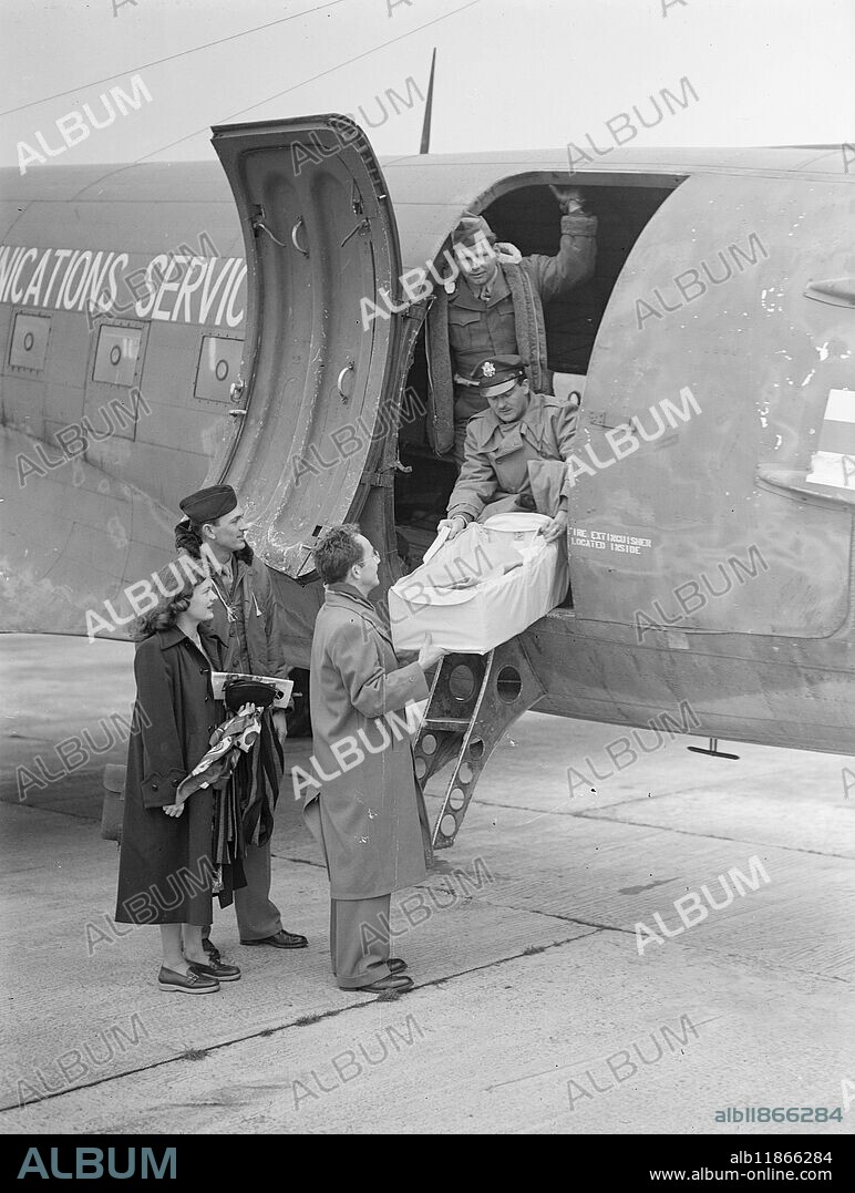 '' TWO NATIONS '' BABY '' AIRLIFTED. MARY LYNNE JARRETT , the baby that was born in the Cunard White Star's QUEEN MARY - during a trip from New York , was flown by United States Air Force Dakota to her new home in Lancashire . He parents , Mr . and Mrs . Edward .C. JARRETT flew with her . Mr . Jarrett is a radar engineer at the air - lift base at Burton wood , near Warrington . His baby is British because she was born on a British ship but - it can retain dual nationality , both British and American if it likes . PICTURE SHOWS ;- Mr and Mrs . Jarrett watch as the baby , hidden under warm coverings , is carefully placed aboard the Dakota at Southampton Airport , Mr . Jarrett is hatless . 23 February 1949.