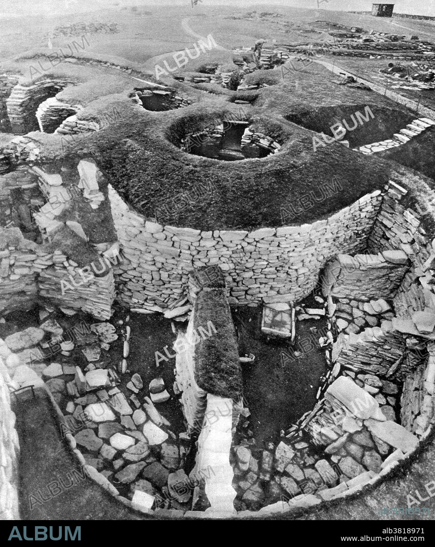 Jarlshof is the best known prehistoric archaeological site in Shetland, Scotland. It lies near the southern tip of the Shetland Mainland and is one of the most remarkable archaeological sites ever excavated in the British Isles. It contains remains dating from 2500 BC up to the 17th century AD. The Bronze Age settlers left evidence of several small oval houses with thick stone walls and various artifacts including a decorated bone object. The Iron Age ruins include several different types of structure including a broch and a defensive wall around the site. The Pictish period provides various works of art including a painted pebble and a symbol stone. The Viking age ruins make up the largest such site visible anywhere in Britain and include a longhouse; excavations provided numerous tools and a detailed insight into life in Shetland at this time. Photograph originally captioned: The Pictish village of Jarlshof as it stands revealed by excavation today: showing the courtyard of the brooch, wheelhouses and (in the background) the remains of the later Viking homesteads. 1952.