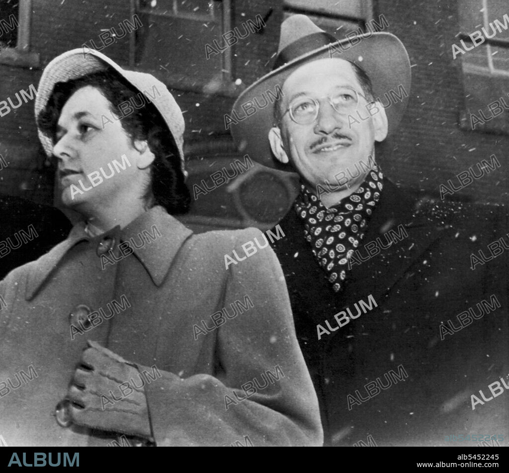 Smiling At The Snow? Dr. Hermann N. Sander, a ski enthusiast, appears to he smiling at the sight of the snow as he leaves court this afternoon on third day of his "mercy killing" trial. Mrs. Sander at left is reserved as usual. February 22, 1950. (Photo by AP Wirephoto).