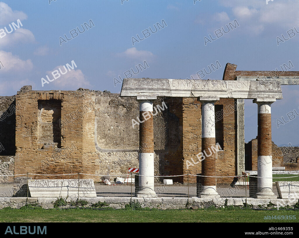 ARTE ROMANO. ITALIA. EDIFICIO DE EUMAQUIA. Construido en época de Tiberio se levantó por orden de la sacerdotisa Eumaquia, para la corporación de los "fullones" (tejedores, lavanderos y tintores), que constituían la mayor industria pompeyana. Entrada del edificio por el PORTICO DE TRAVERTINO. (Area del Foro). POMPEYA. La Campania.