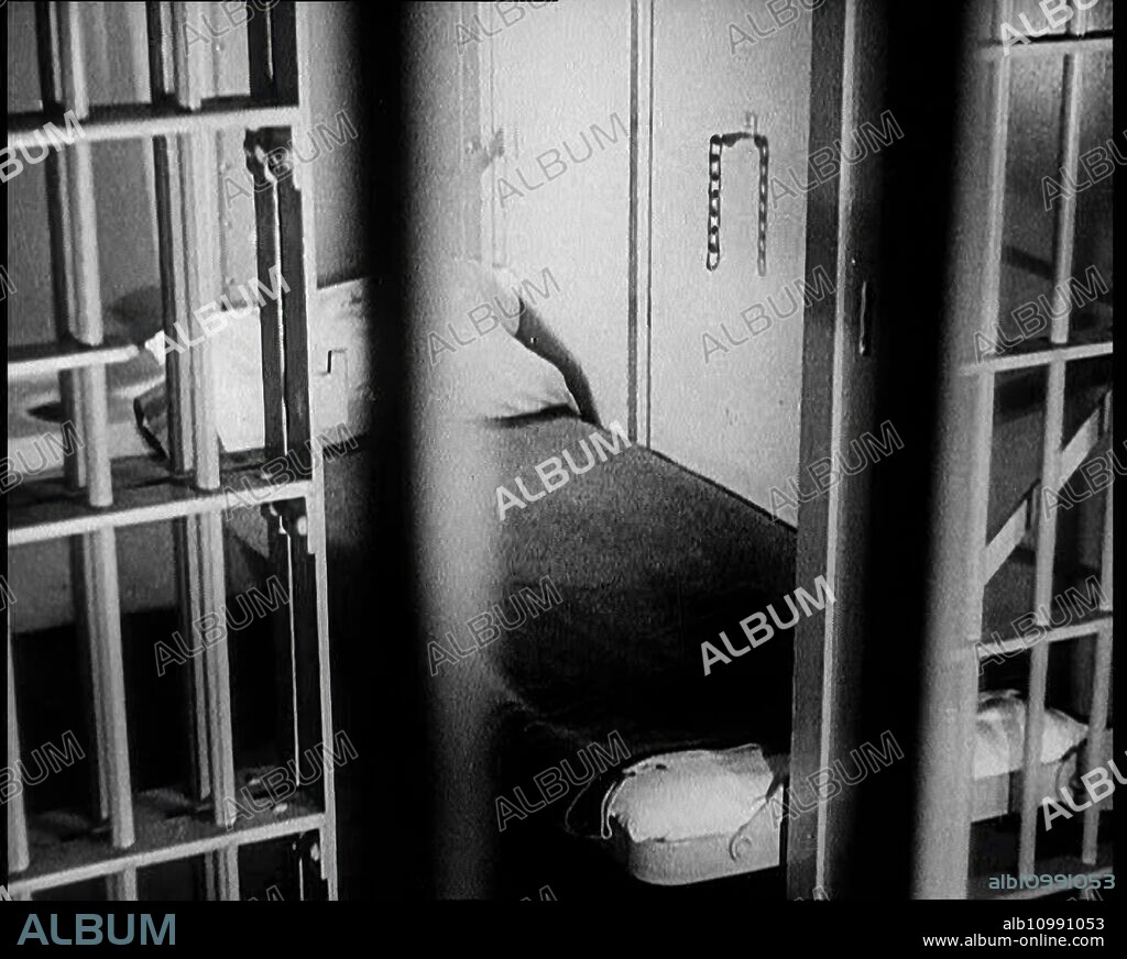A Prison Cell, 1930s. "The crime of the century" - the Lindbergh kidnapping case, USA. 'Hauptmann appealed to be released on bail, but when he was brought before the judge, such was the nature of his crime, that there was little hope...The state was in no mood to be lenient, so into jail he went'. From "Time To Remember -  The Tough Guys", 1930s  (Reel 3); documentary film, mainly about life in depression- and gangster-hit America.