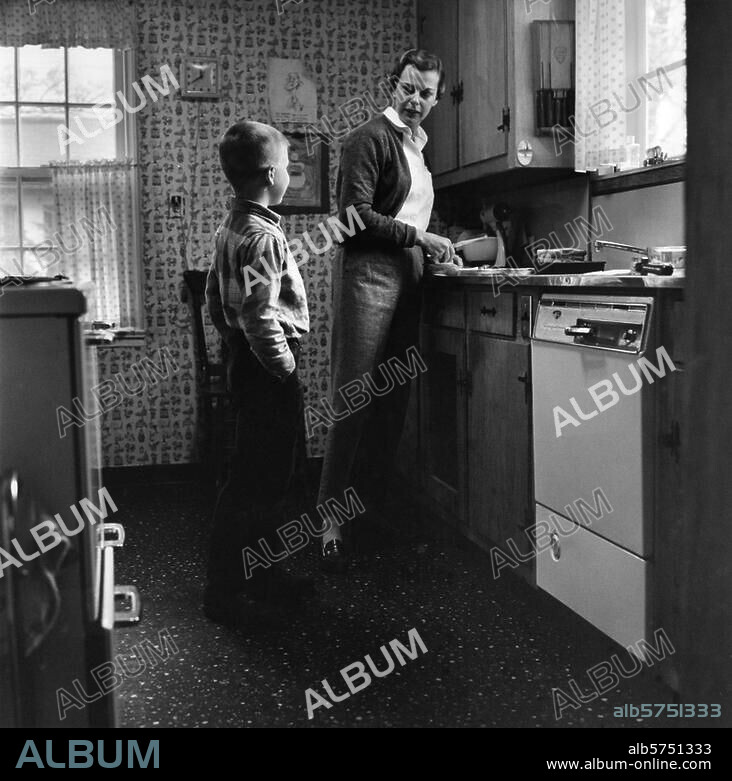Family:. Mother and Child. A mother making a sandwich for her son. Photo, USA, 1960. From a series: "Vie familiale". (Family life).