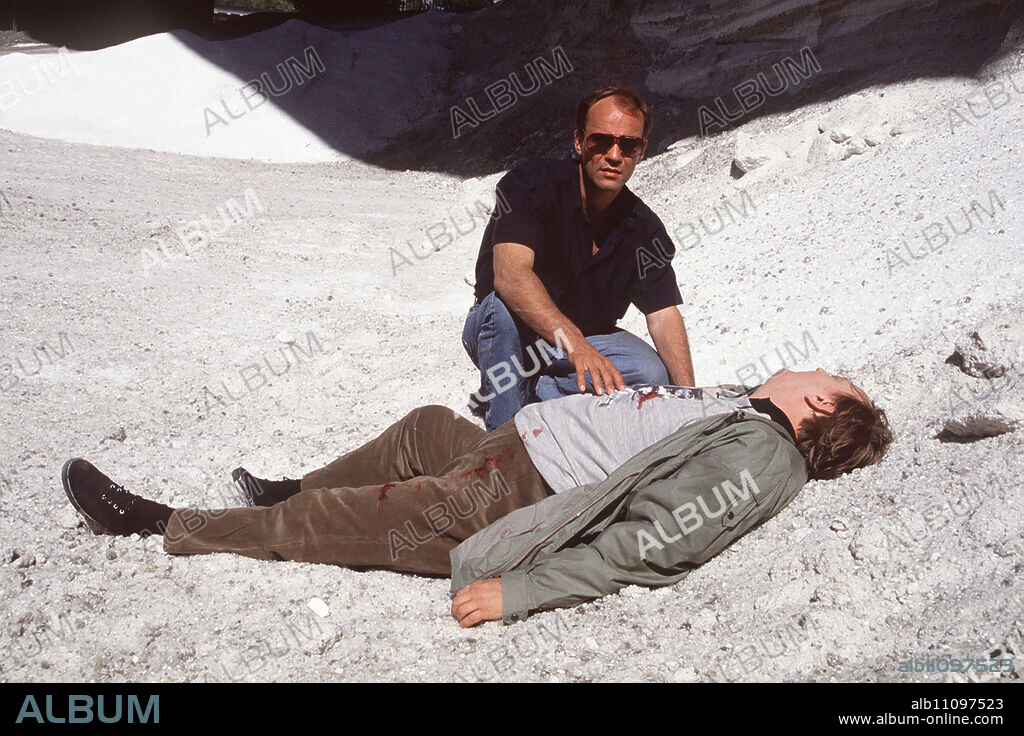 Thommy tells Inspector Dorn an unbelievable story: he has allegedly just witnessed his father being murdered in the forest. Dorn actually finds a body at the specified location. The inspector soon no longer believes that it is Tommy's father. Image: Thomas Dorn (HEINER LAUTERBACH), Dead Man (DIETER PFAFF) Director: Jörg Grünler aka. Tommy's Story / Headline: EUROCOPS / BRD 1990.