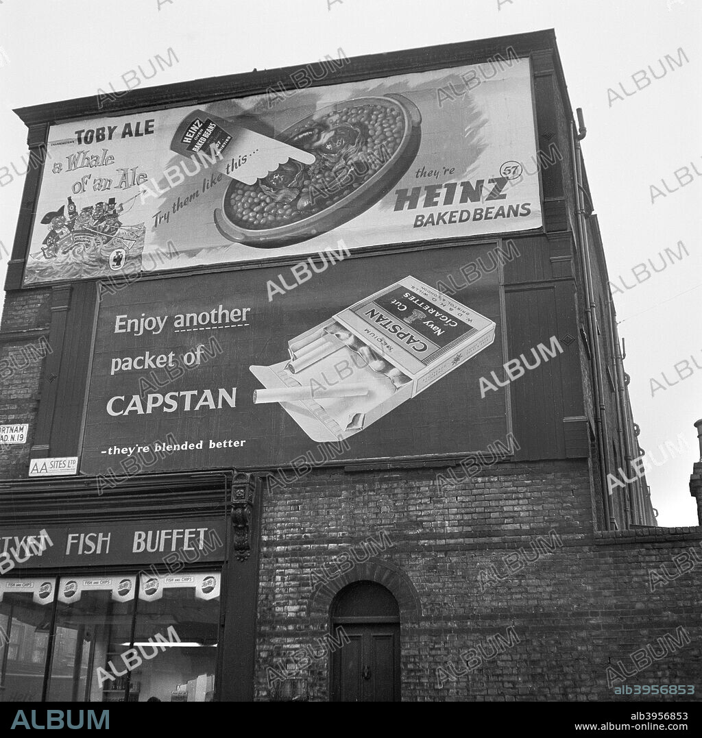 Advertising hoardings, Fortnam Road, Holloway, London, 1960-1965. Posters for Toby Ale, Heinz Baked Beans and Capstan cigarettes above a chip shop on the corner of Fortnam Road.