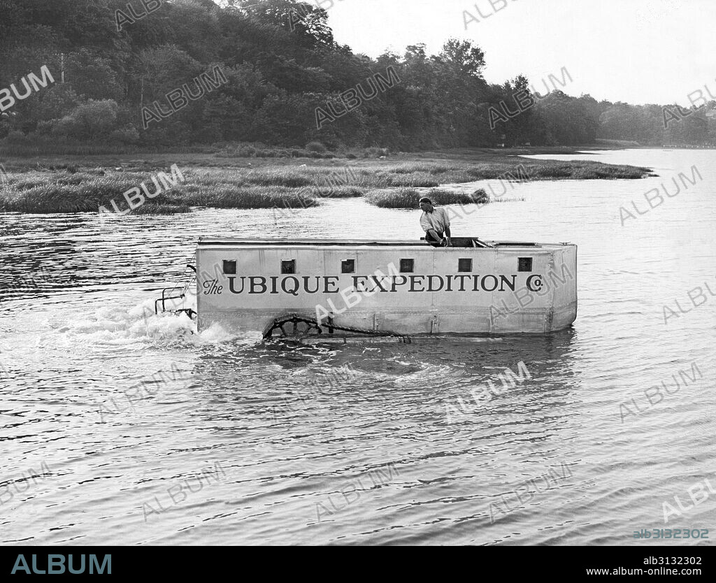 Kings Point, New York:  c. 1933 Explorer John H. Ubique tests out his amphibian vehicle with which he hopes to lead an expedition into the jungles of South America in a search tp find the lost avaitor, Paul Redfern. It has tractor treads and paddles to propel it.
