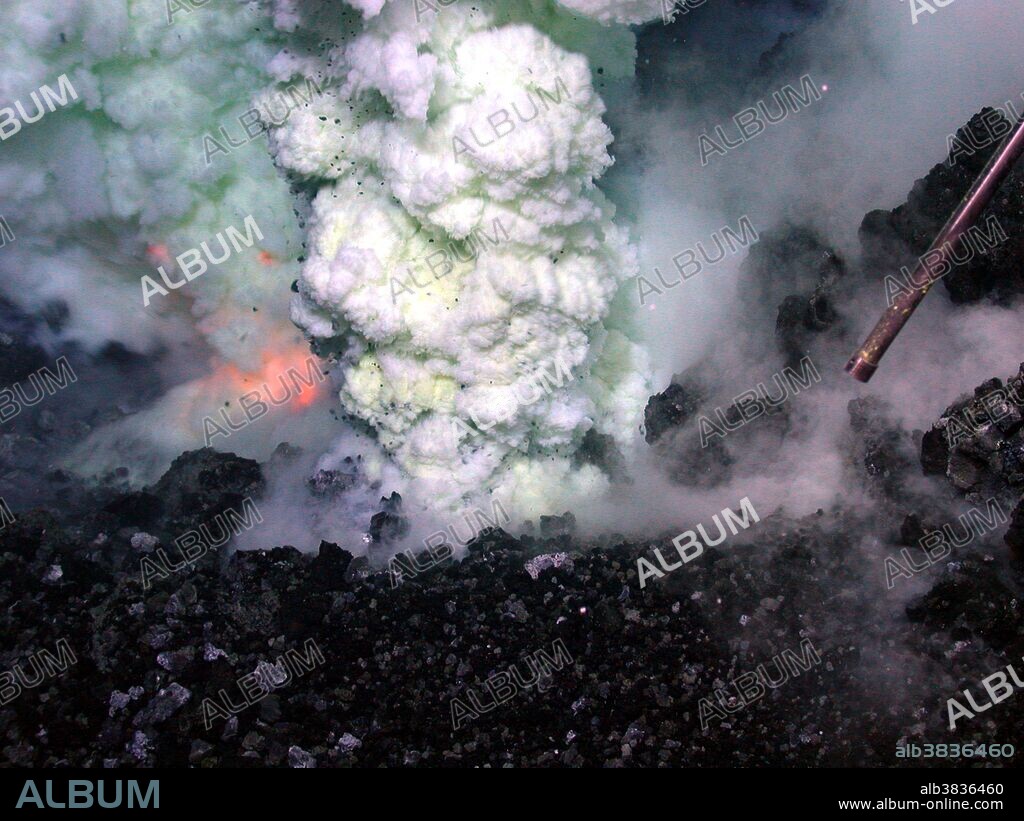 Eruption of the West Mata volcano, discovered in May 2009, occurring nearly 4,000 feet below the surface of the Pacific Ocean, in an area bounded by Fiji, Tonga and Samoa. It is the deepest erupting volcano discovered to date. In this image, the orange glow of magma is visible to the left of the sulfur-laden plume. Image is about six feet across in an eruptive area of about 100 yards running along the volcano's summit.