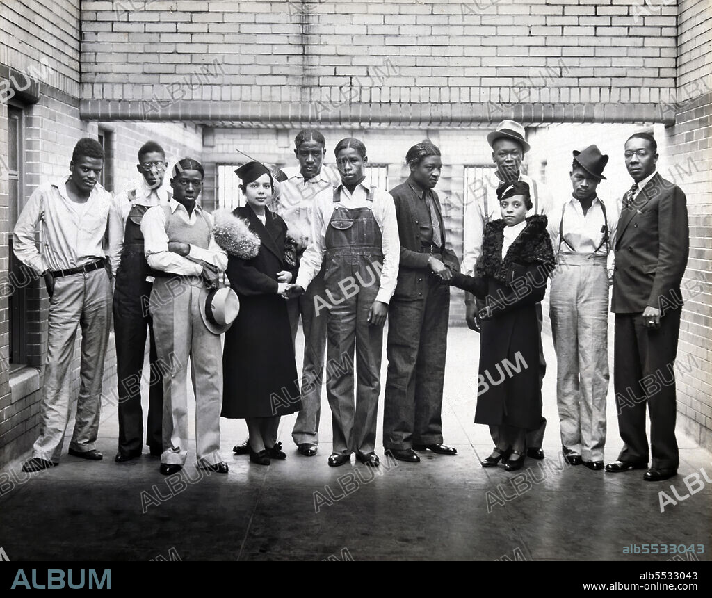 Eight of the nine Scottsboro Boys, Ozie Powell, Olen Montgomery, William Roberson, Charles Weems, Clarence Norris, Haywood Patterson, Andrew Wright and, Eugene Williams, falsely accused of raping two white women, with NAACP representatives Juanita Jackson Mitchell, Laura Kellum, and Dr. Ernest W. Taggart, full-length Portrait inside Prison, Alabama, USA, Britton & Patterson, 1936.