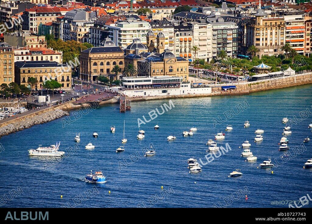 Barco turístico saliendo del Puerto rumbo a la Isla Santa Clara, Detrás los edificios del Real Club Nautico y del Ayuntamiento, Donostia, San Sebastian, Ciudad cosmopolita de 187.000 habitantes, destaca por su gastronomía, playas urbanas y edificios inspirados en la arquitectura parisina, Gipuzkoa, Basque Country, Spain, Europe.